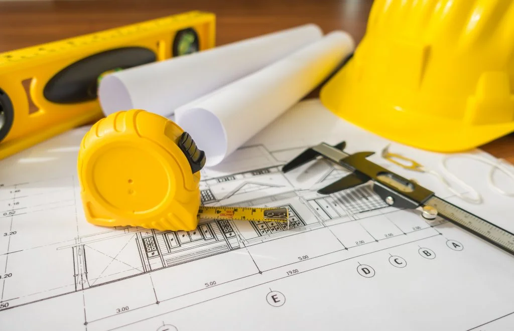 construction-plans-with-yellow-helmet-drawing-tools-bluep-1024x660